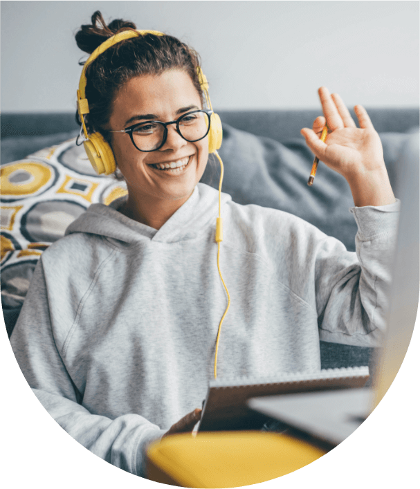 Smiling young tutor wearing yellow headphones waving during online class