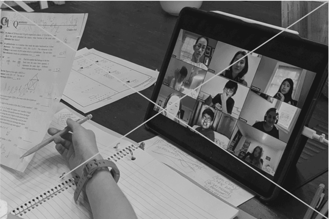 Élève suivant un cours en visioconférence avec des camarades, cahiers et exercices de mathématiques posés sur la table
