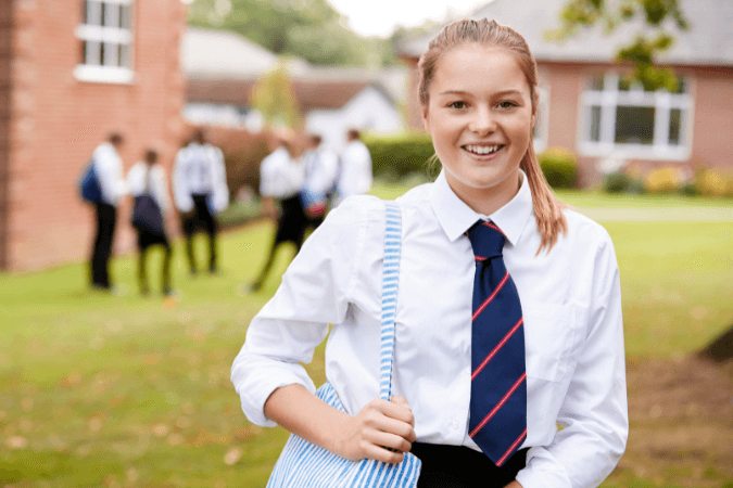 Étudiante en uniforme scolaire devant école privée illustrant ce qui rend ces établissements si convoités